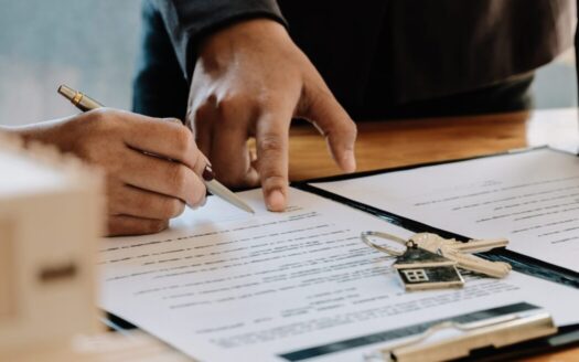 Foreign property owner signing documents for selling real estate in Greece in 2025 with Greek coastal property in background.