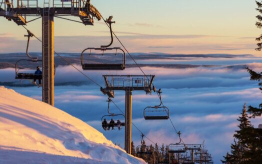 Snow-covered Greek ski resort with chalets and mountain views for real estate investment opportunities