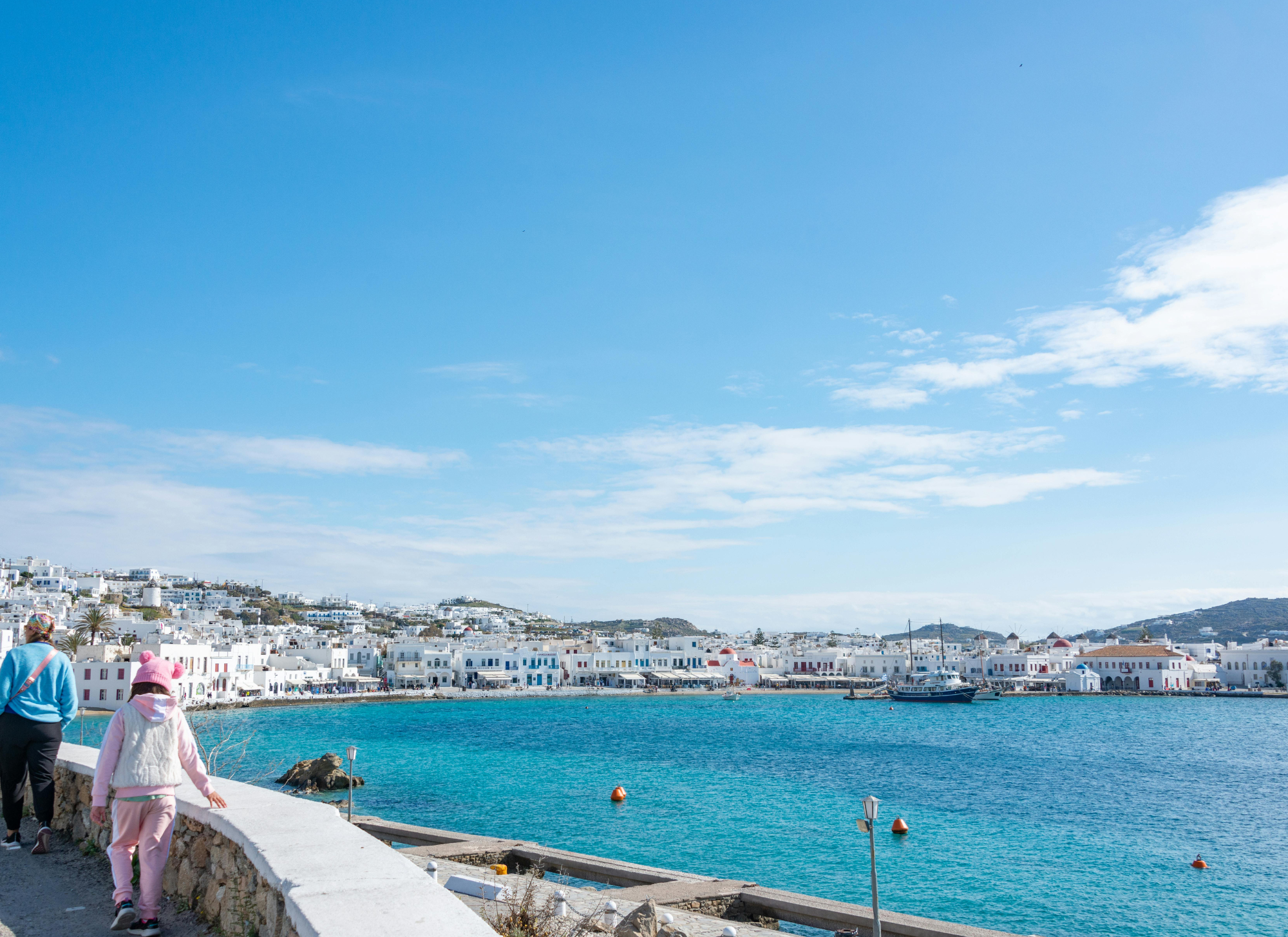 Greek coastal town with sea-view houses, popular for second home buyers seeking property investment and lifestyle benefits.