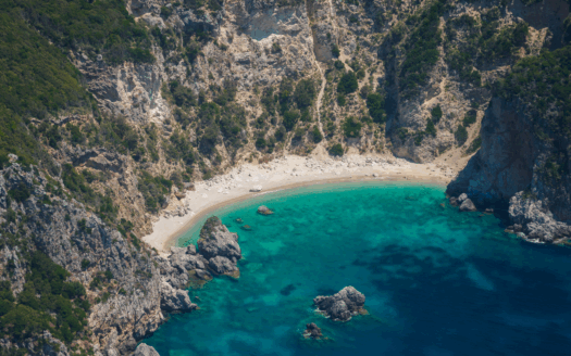 Aerial view of Corfu's coastline, illustrating the island's appeal to tourists and potential property investors.