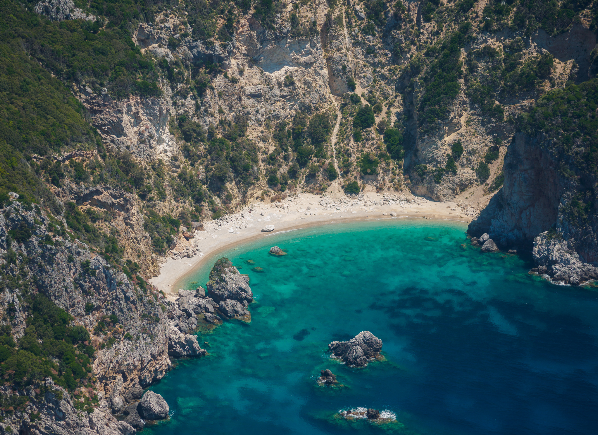 Aerial view of Corfu's coastline, illustrating the island's appeal to tourists and potential property investors.