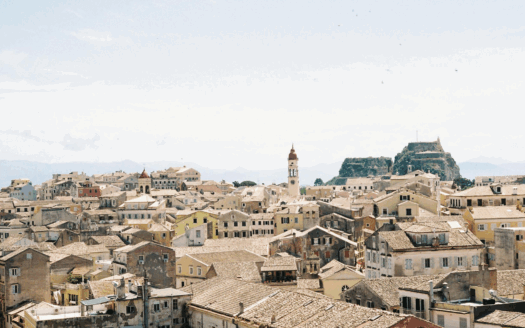 A panoramic view of Corfu, showcasing a mix of coastal and rural areas, perfect for finding the right vacation home location.