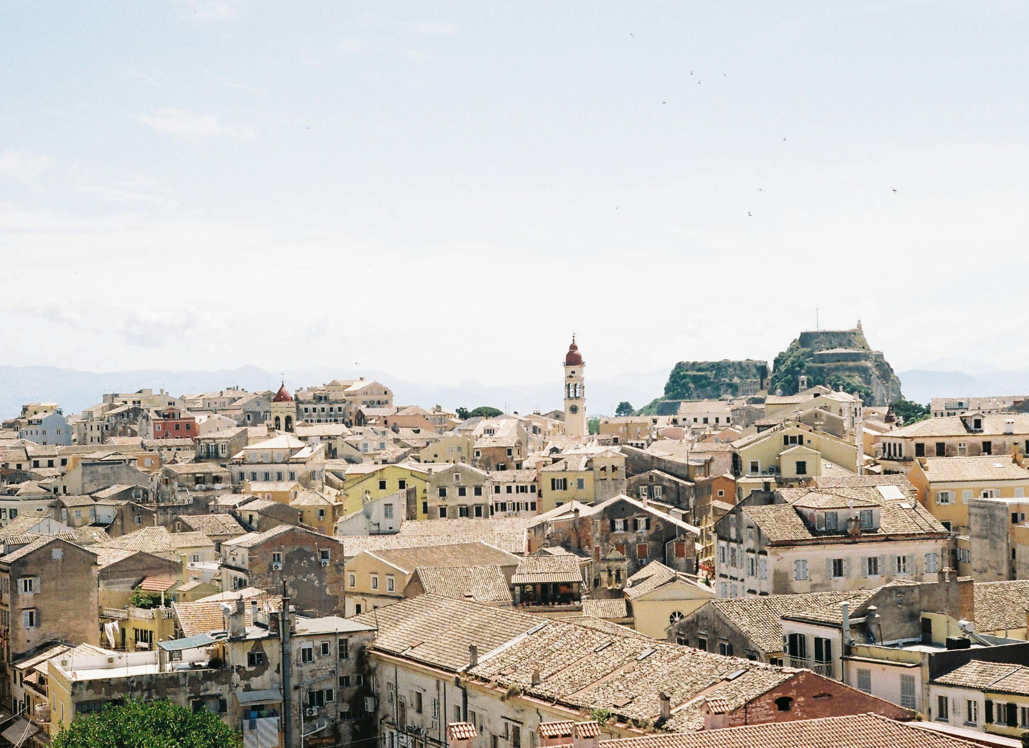 A panoramic view of Corfu, showcasing a mix of coastal and rural areas, perfect for finding the right vacation home location. 