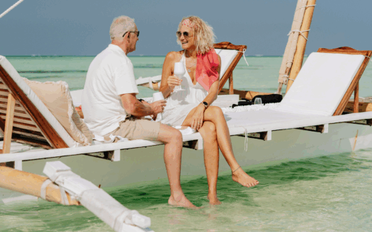 Retired couple enjoying the sea view from their Corfu villa, surrounded by Mediterranean scenery.