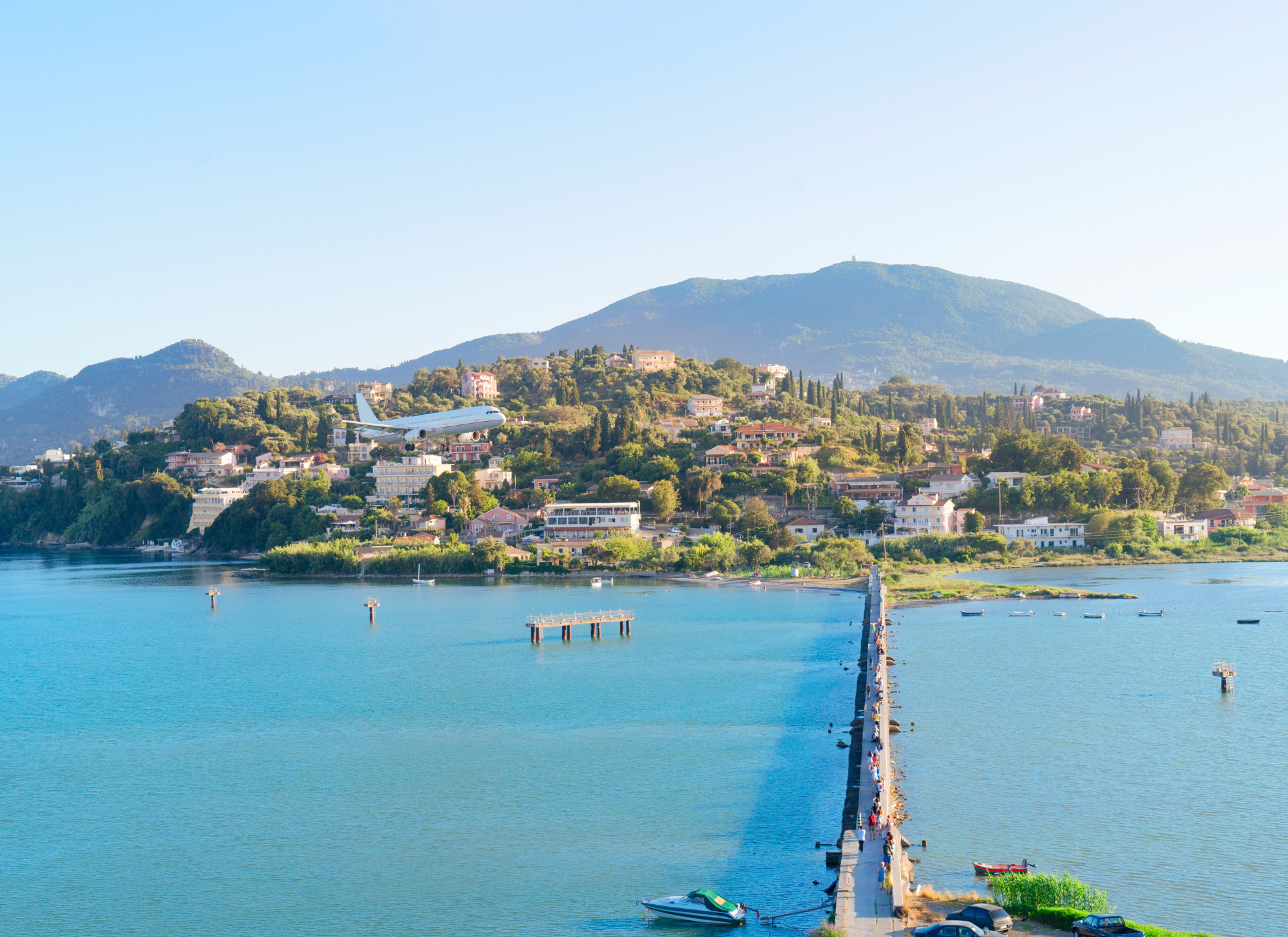 Kassiopi village with scenic harbor and clear blue water.