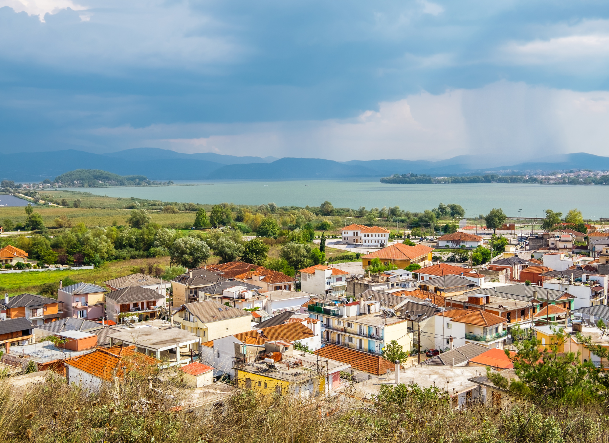 Quiet streets of Perama with local shops and green surroundings.